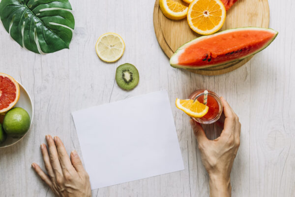crop-hands-with-smoothie-near-fruits-paper-sheet